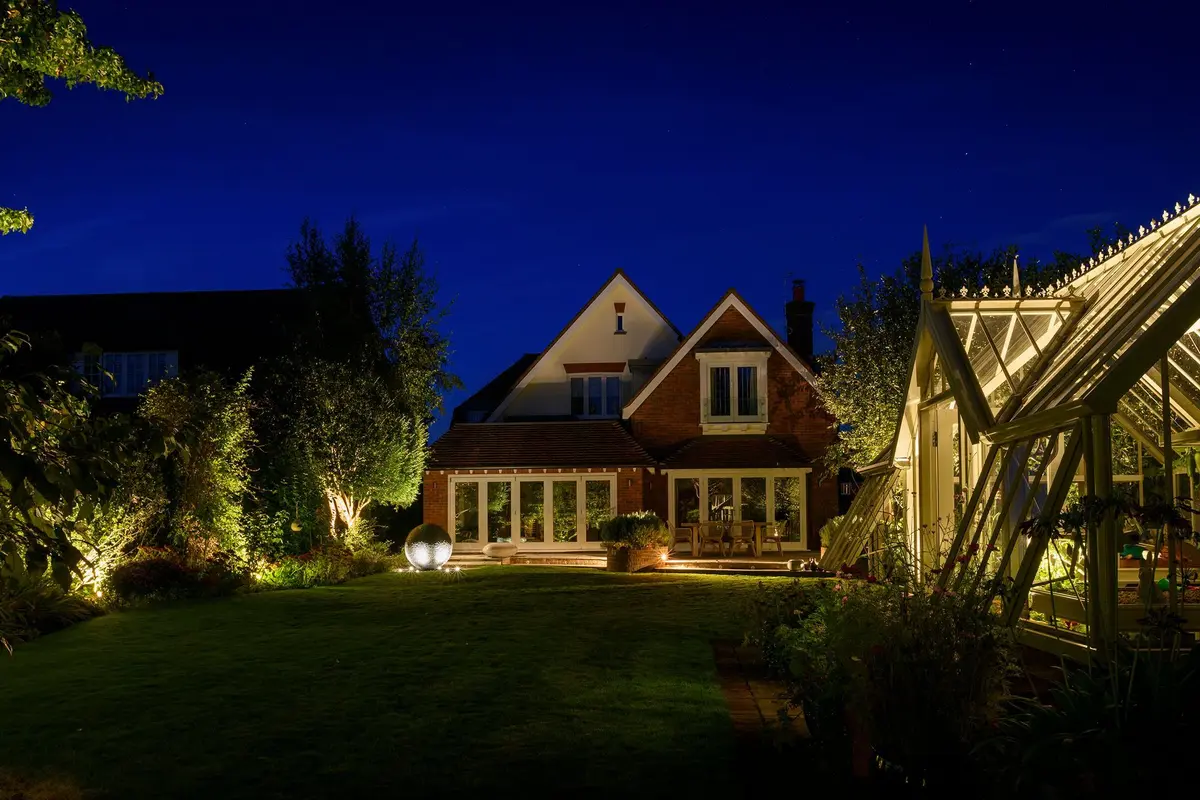 Rear elevation of an Eastbourne home lit with warm landscape lighting at dusk